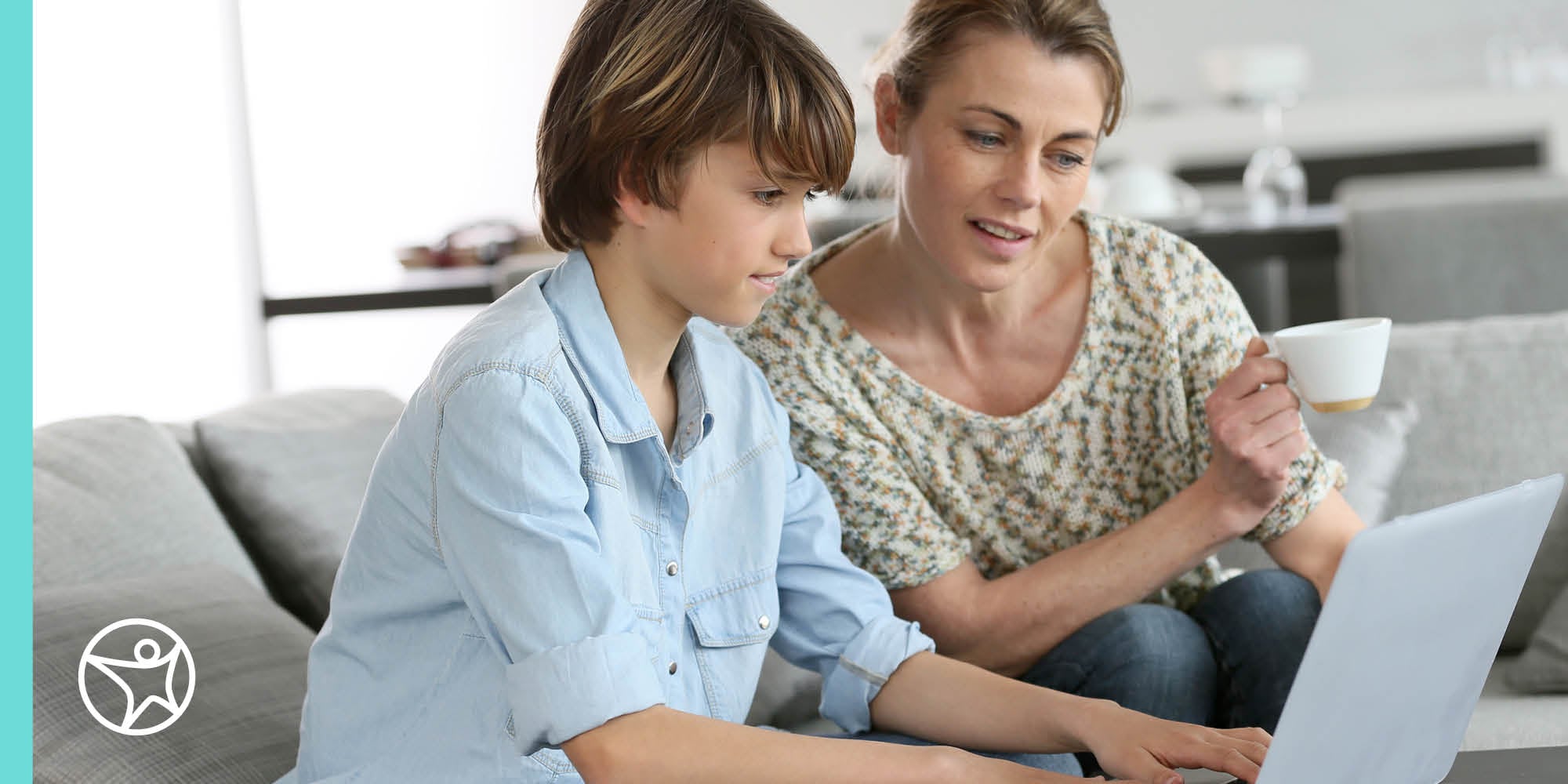 A mother is looking at a laptop with her son