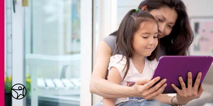 A mom and daughter looking at a tablet together