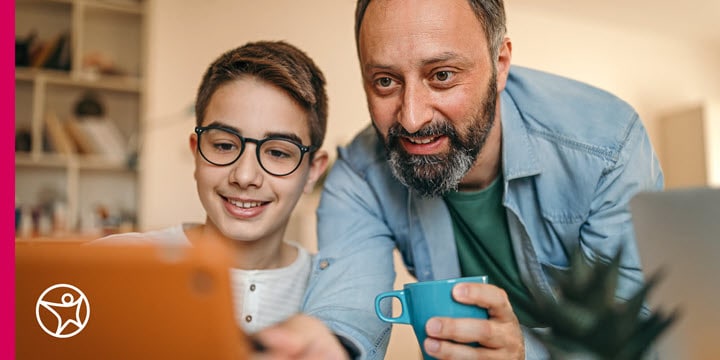 A father is helping his son on the computer