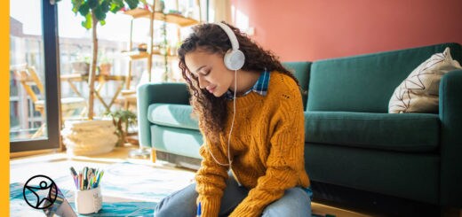 A teenager is sitting down listening to headphones