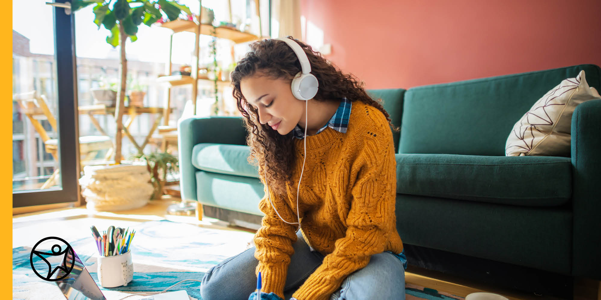 high school girl sitting on floor with pen paper and laptop