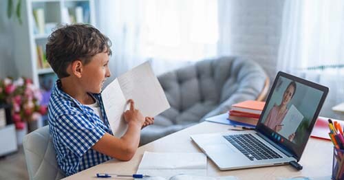 Teacher meets virtually with student to help him through a tough problem making online school versus traditional education feel much more personalized