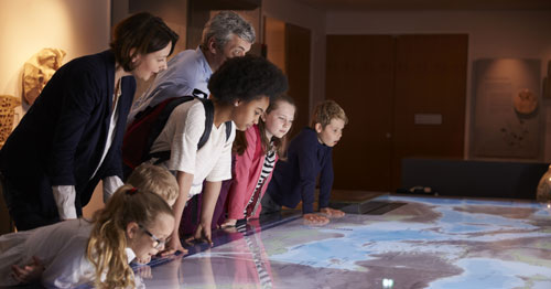 An online school class on a field trip looking at a display panel