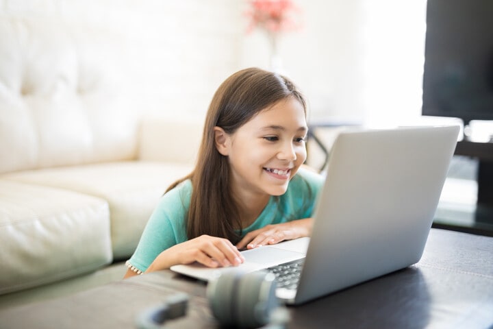 A young student is lisitening to their online elementary school lesson