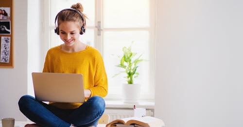 High school student completes free typing game on laptop at home