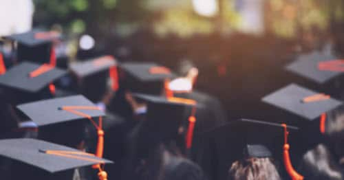 Graduating students standing in commencement caps