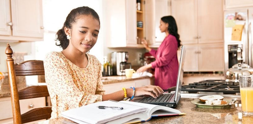 Young girl sitting on herdinning table doing homework
